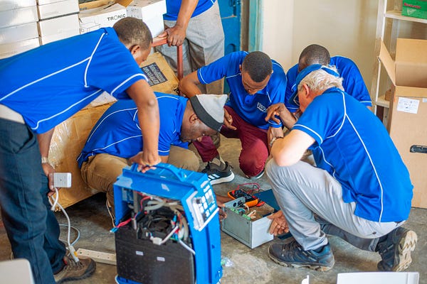 PHOTOS FROM FREO2’S WORK IN TANZANIA. LEFT - THE TEAM HAVING A MAINTENANCE TRAINING SESSION. RIGHT- TWO OXYGEN CONCENTRATORS. RIGHT - A BABY