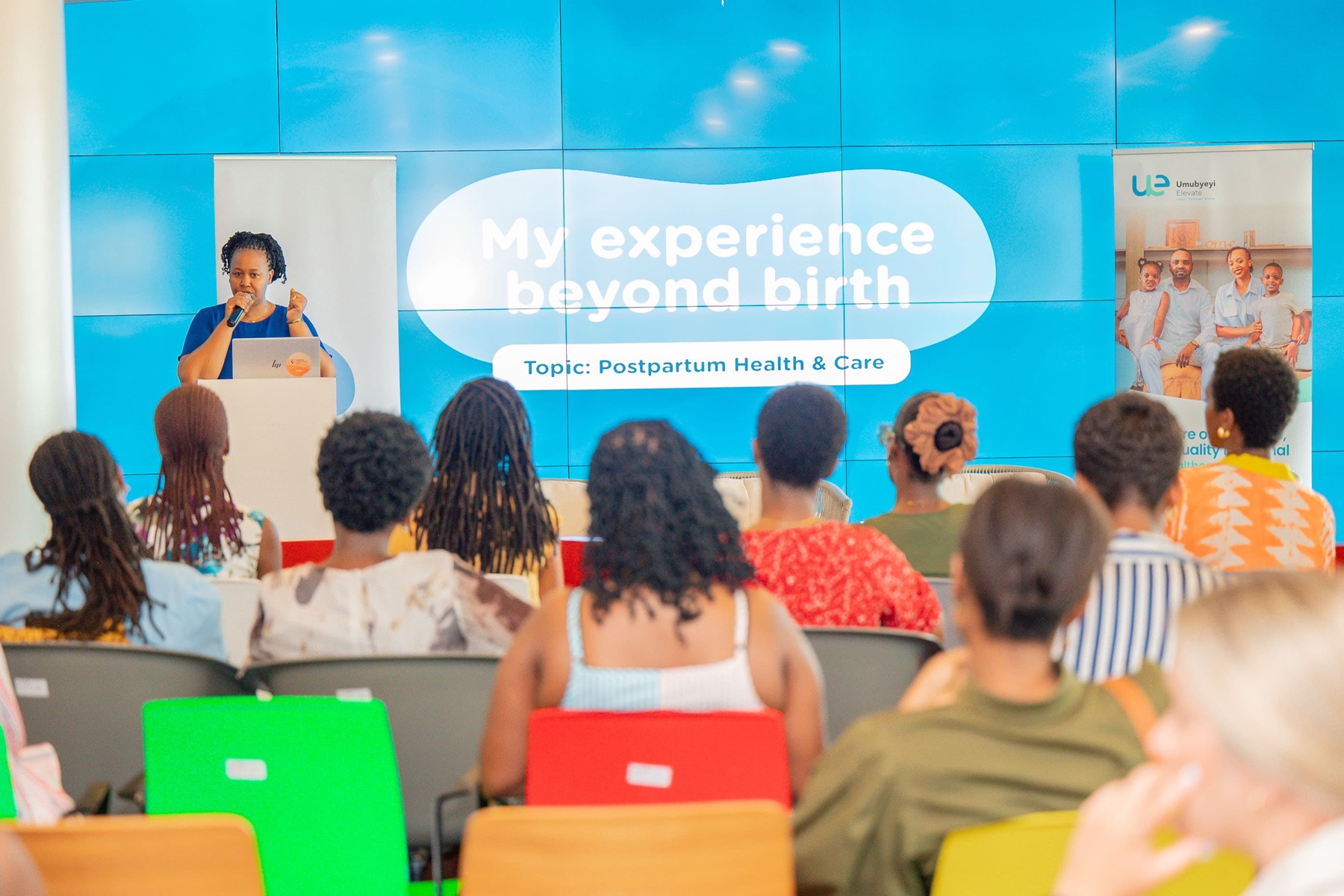 A speaker presents on postpartum health and care to an audience at a Hanga SRH convening